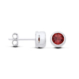 Sterling silver stud earrings with round natural garnets, pictured from the front and side on a white background.