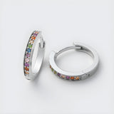 Sterling silver huggie hoops with multicolored cubic zirconia stones in a rainbow pattern.