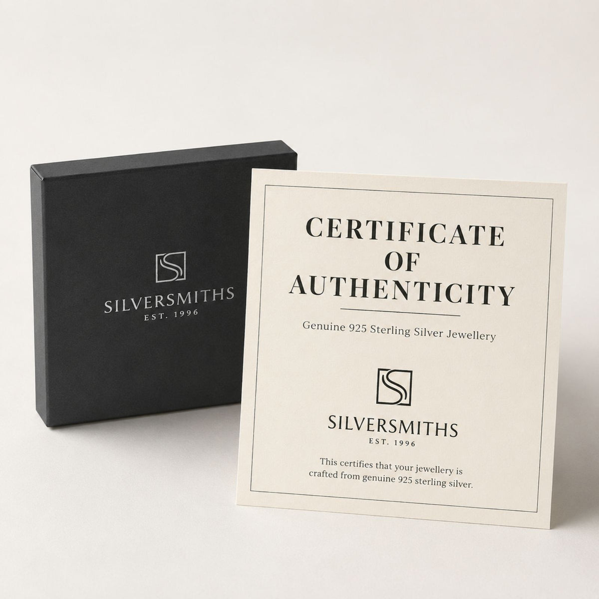 A black Silversmiths box sits next to a certificate of authenticity for 925 sterling silver jewellery.