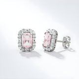 Sterling silver stud earrings with simulated pink sapphires encircled by a sparkling halo design.