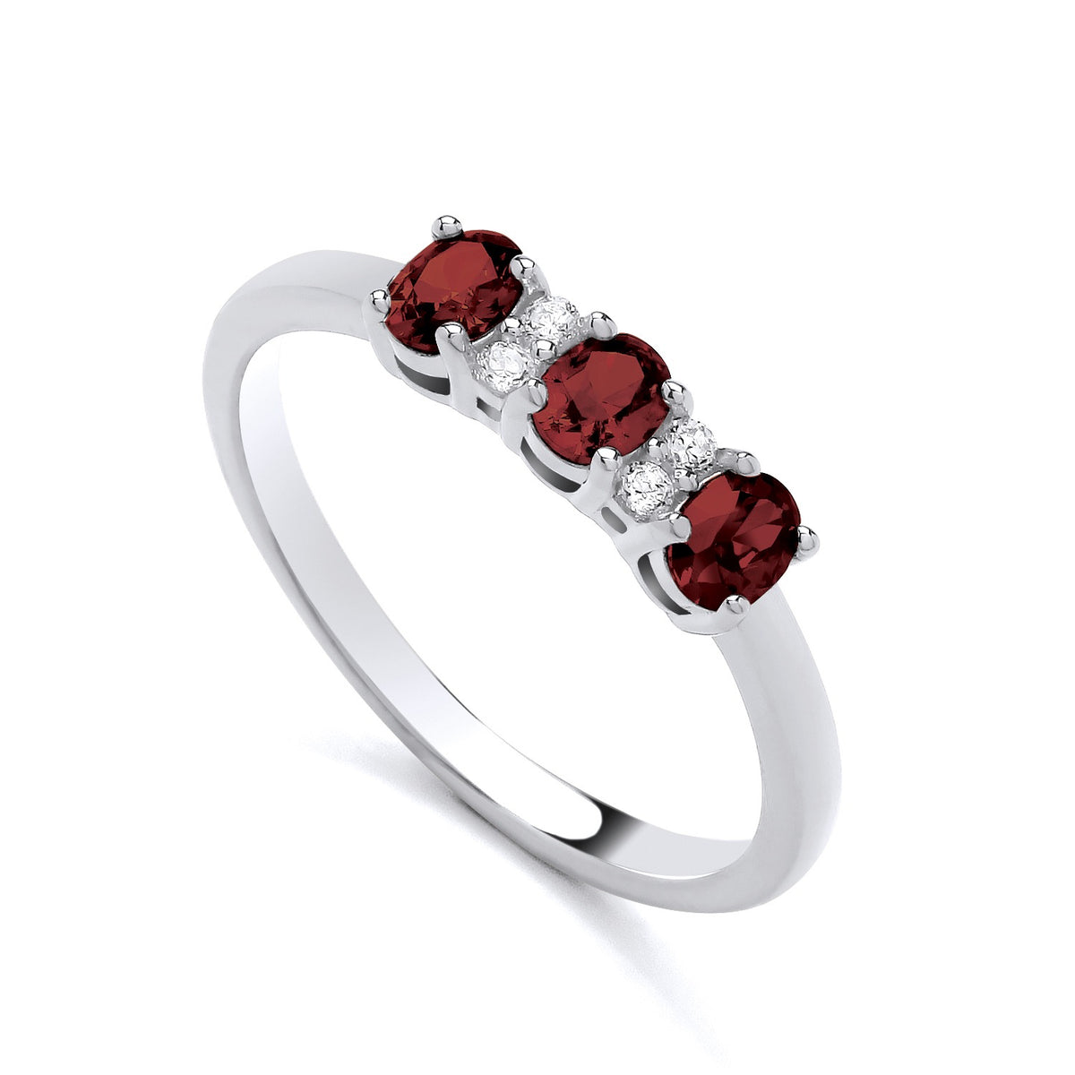 Sterling silver ring with three simulated rubies and four cubic zirconia in a trilogy design by Silversmiths.
