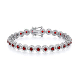 A sterling silver tennis bracelet with 6.5mm simulated ruby halo stones displayed on a white background.