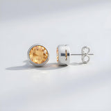 Sterling silver stud earrings feature round natural citrine stones, displayed against a light background.