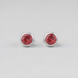 Silversmiths sterling silver stud earrings with simulated garnet stones, displayed on a sleek gray background.