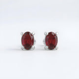 Silversmiths sterling silver stud earrings with natural oval garnets.