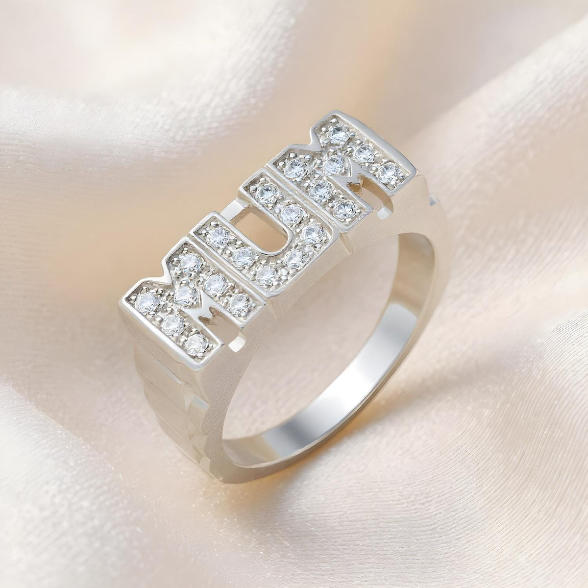 The Silversmiths ring features sterling silver and cubic zirconia with the word “MUM” on the front.