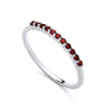 A thin sterling silver band featuring simulated ruby stones set along the top half.
