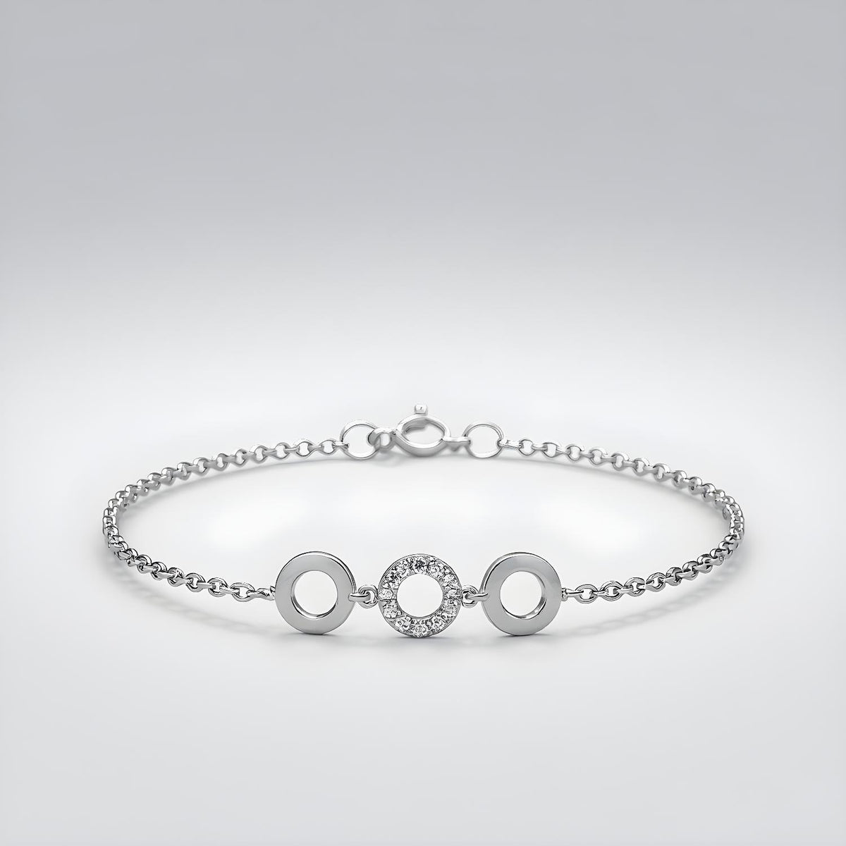 A sterling silver bracelet with three cubic zirconia circle stations is pictured on a plain background.