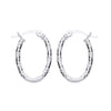 21mm sterling silver oval hoop earrings with diamond-cut finish and hinged clasps on a white background.