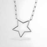 A sterling silver paperclip chain necklace with an open star pendant displayed on a plain white background.