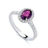 Sterling silver ring with a simulated amethyst center, cubic zirconia halo, and accent stones.
