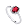 Sterling silver ring by Silversmiths featuring an oval simulated ruby and clear stones in a halo cluster setting.