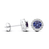 Sterling silver stud earrings feature simulated tanzanite blue stones surrounded by CZ halos in a silver setting.